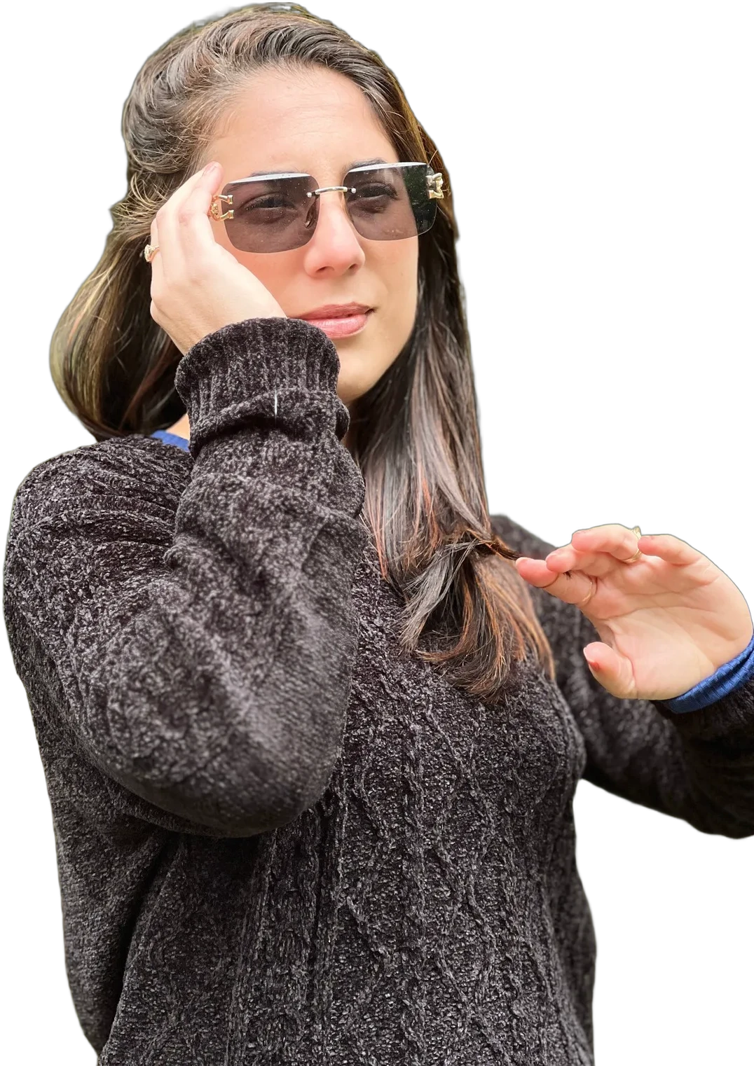Susana González Obregón con suéter gris, ajustándose las gafas de sol con una mano y sosteniendo un mechón de pelo con la otra