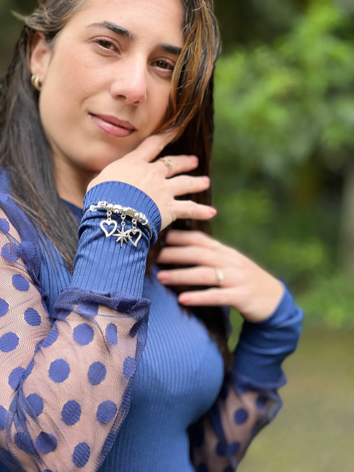 Susana González Obregón con blusa azul, mirando a cámara con la mano apoyada en el pelo